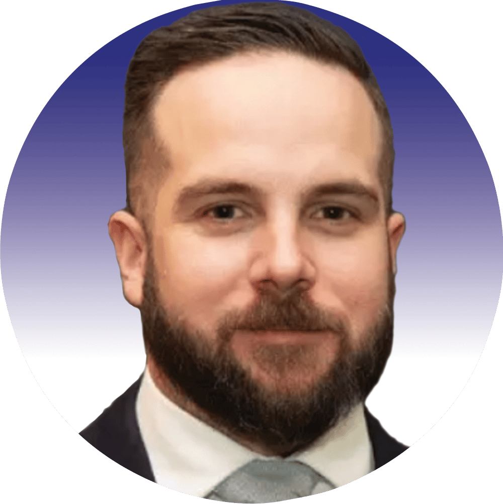 Headshot of a smiling man with dark hair and beard, wearing a suit and tie.