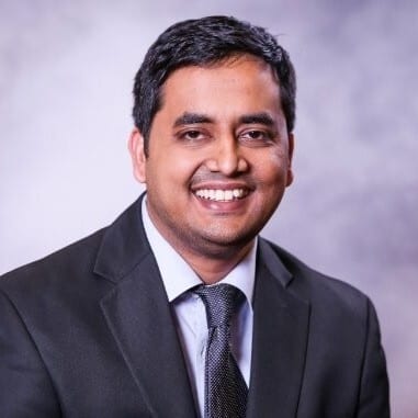 Smiling man in a suit and tie.