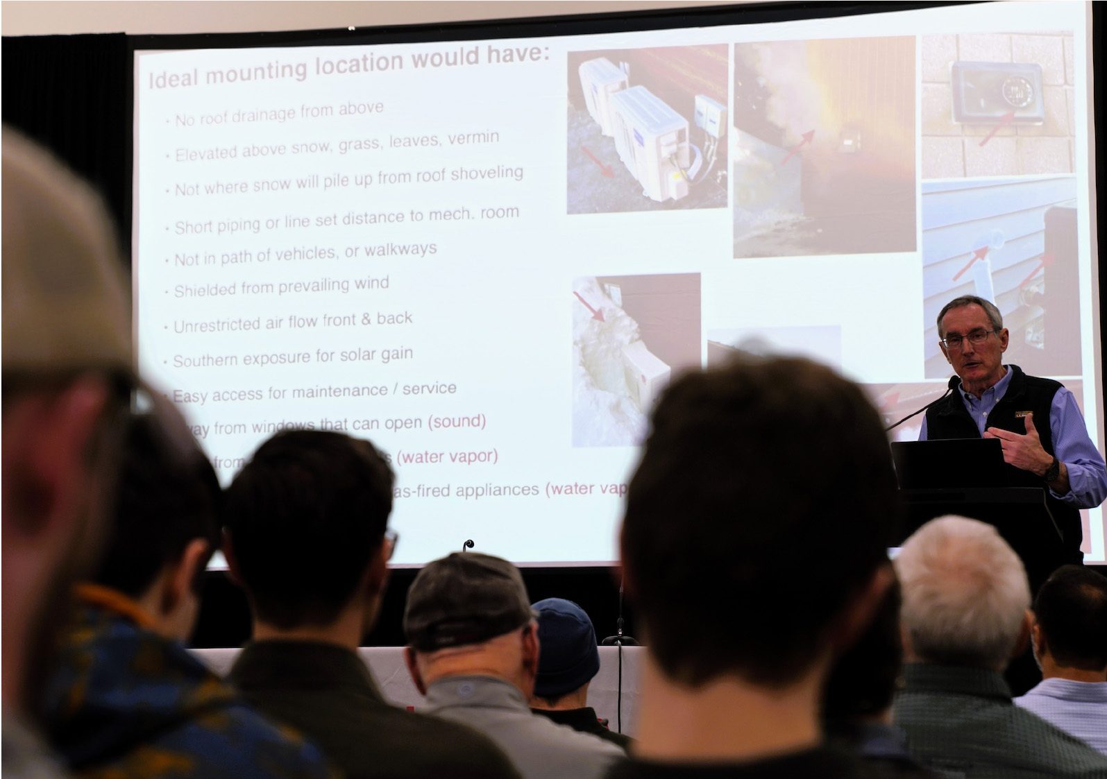 A speaker presents information on "Ideal mounting location" to an audience, with relevant images on screen.