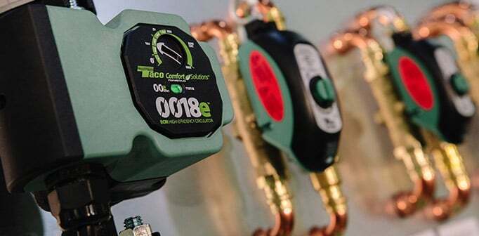 Green and black Taco ECM high-efficiency circulator pump with digital display. Plumbing visible.