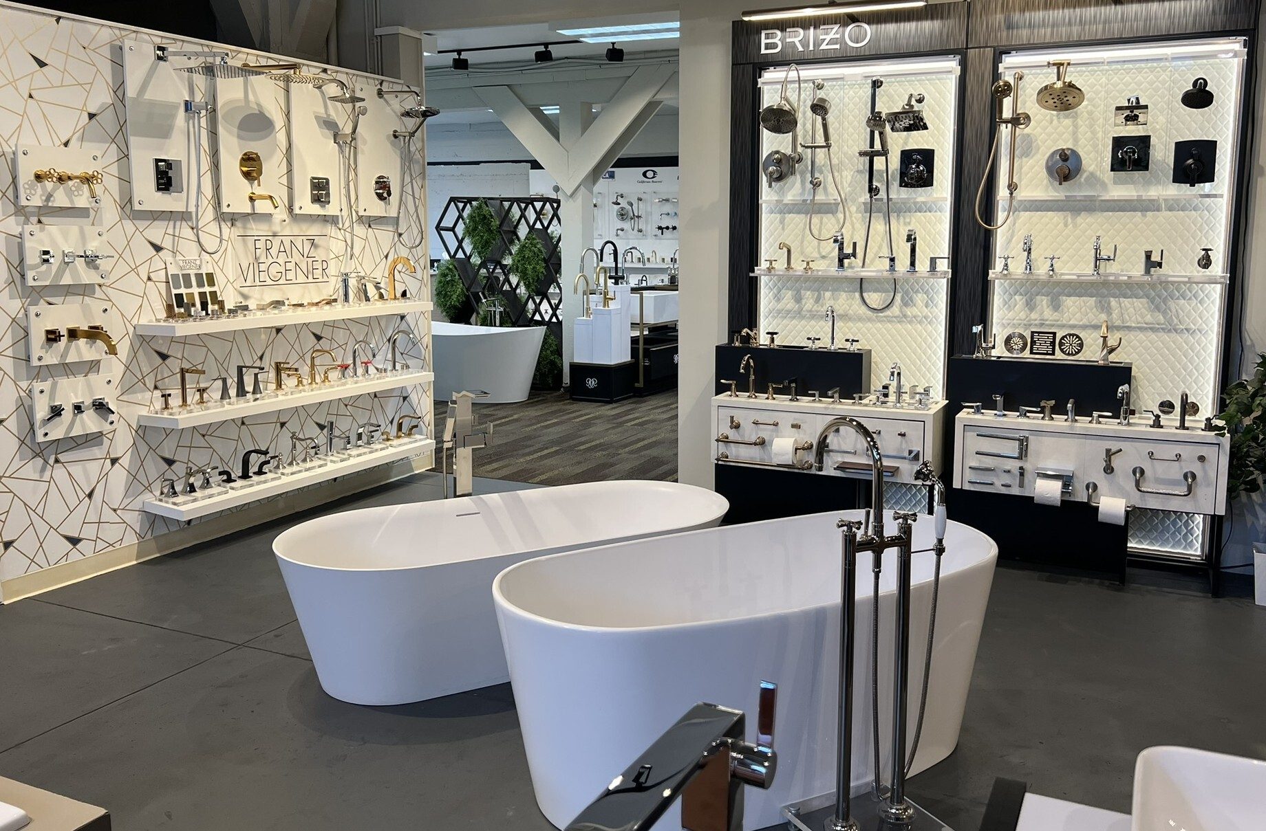 Modern bathroom showroom featuring bathtubs, Franz Viegener and Brizo faucets, and showerheads.