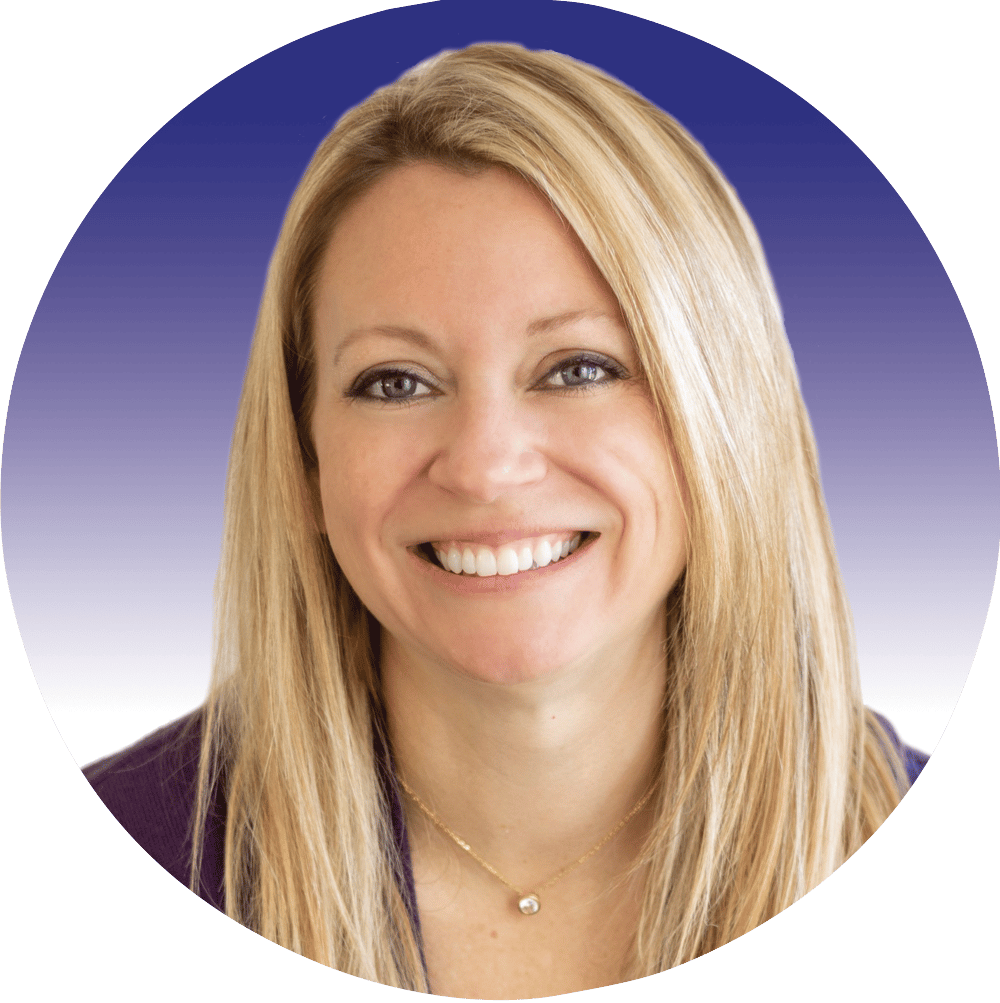 Smiling blonde woman with blue eyes and a gold necklace.