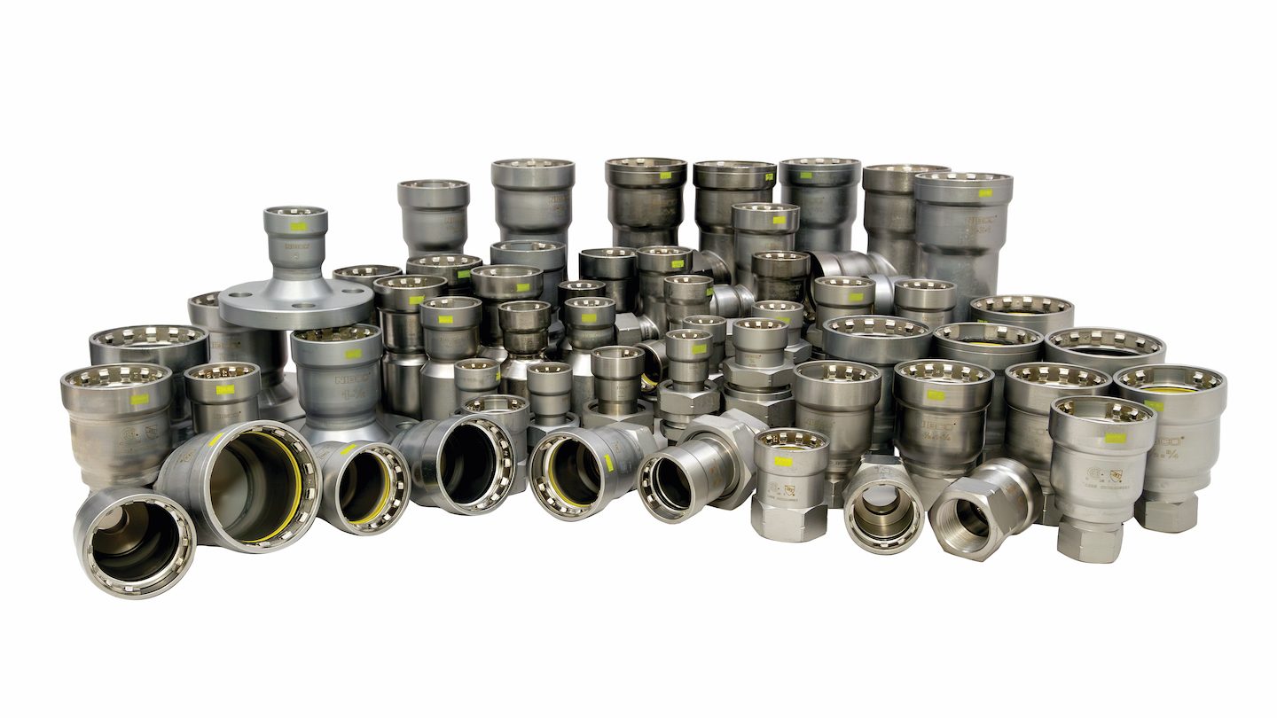 A diverse collection of shiny metal pipe fittings and connectors on a white background.