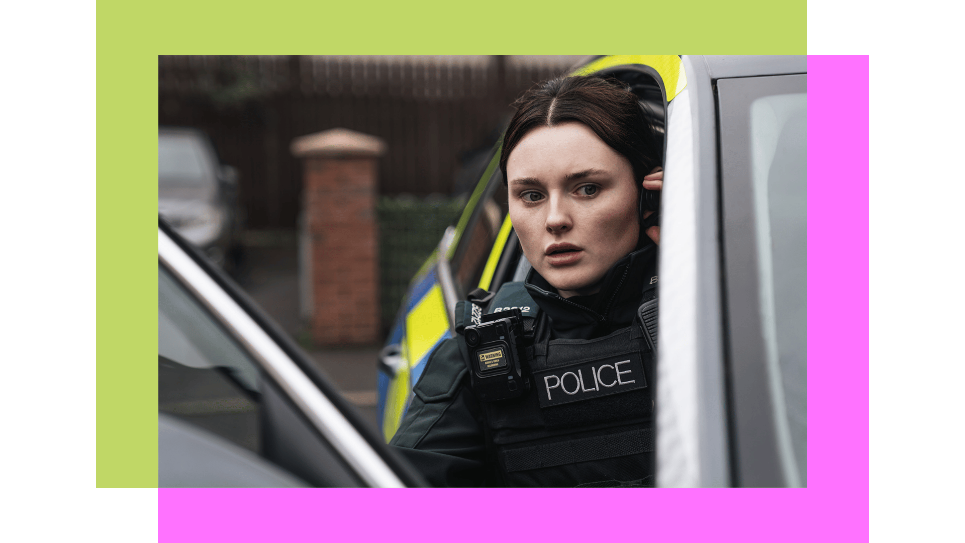 Alert female police officer in uniform, bodycam, holding a radio, beside police car.