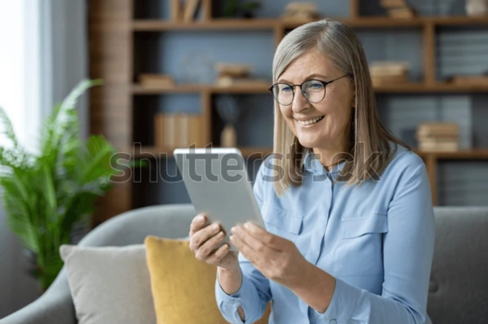 Electronic device, Facial expression, Tablet computer, Smile, Happiness, Sitting, Comfort, Gadget, Furniture, Technology