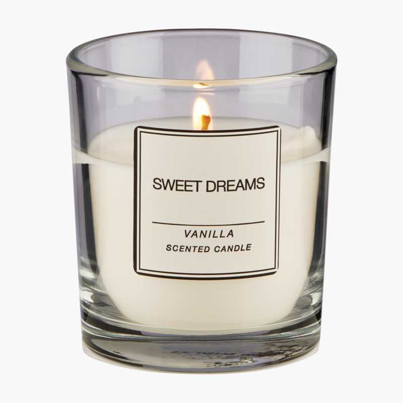 Lit vanilla scented candle in a glass jar with a "Sweet Dreams" label.