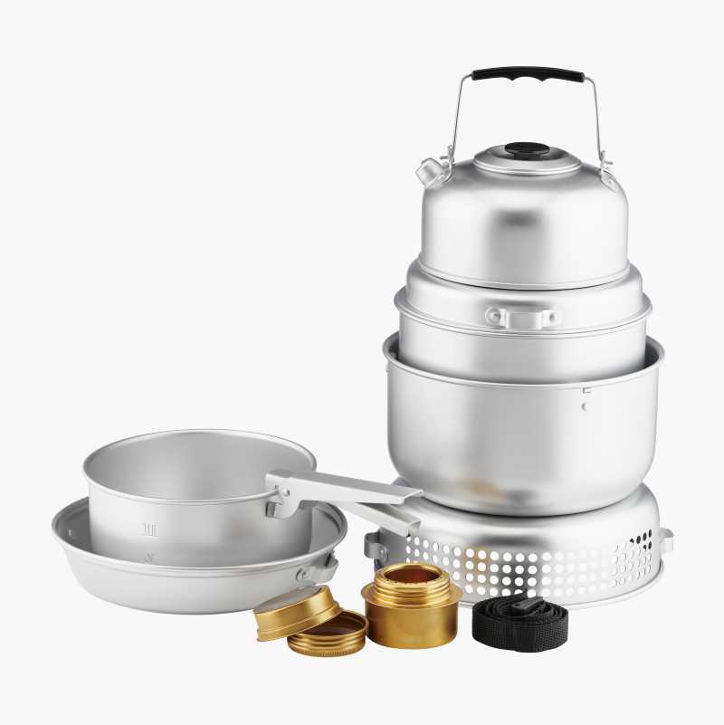 A silver camping cookware set, including stacked pots, a kettle, frying pan, and a stove base.