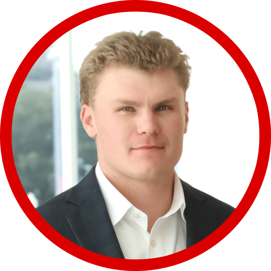 Young man in suit, blonde hair, blue eyes, looking at camera.