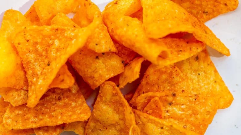Pile of orange, seasoned triangular chips.