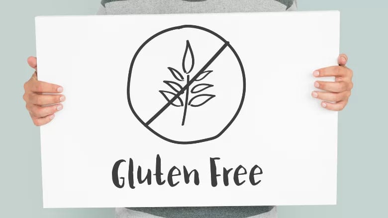 Hands holding a sign with a gluten-free symbol and "Gluten Free" text.