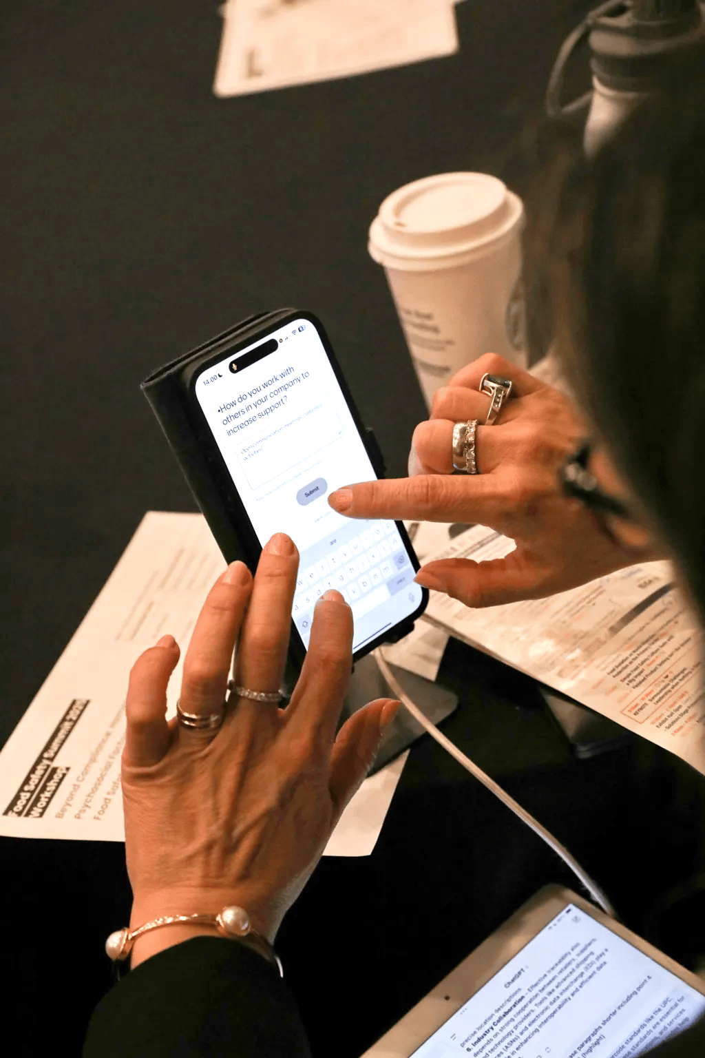 Hands typing on a smartphone showing a survey question about increasing company support.