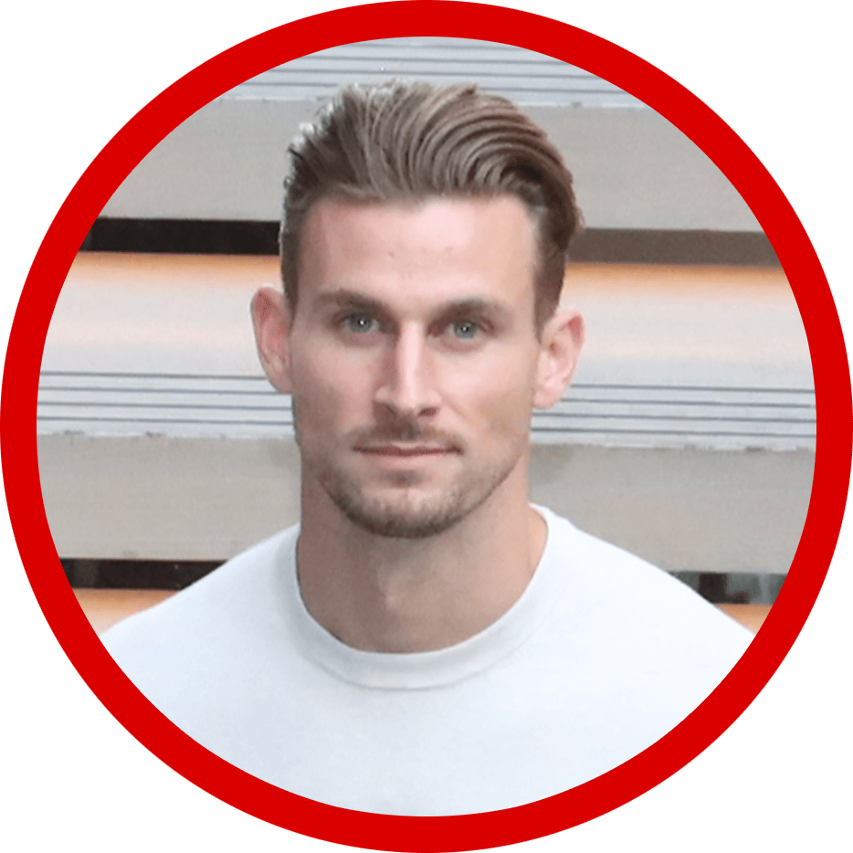 A portrait of a man with light brown hair and blue eyes, wearing a white t-shirt.