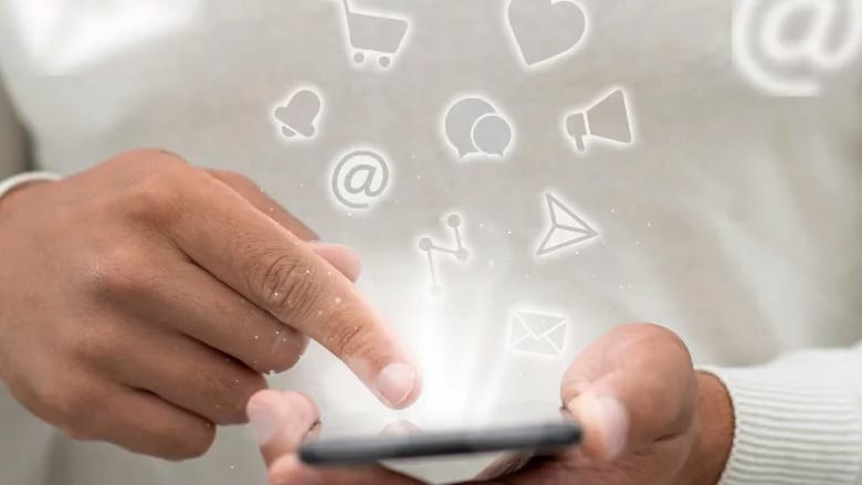 Person using a smartphone, emitting glowing social media and communication icons.