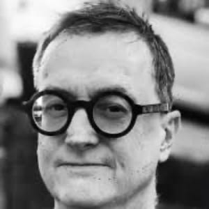 Black and white photo of a man wearing round glasses.