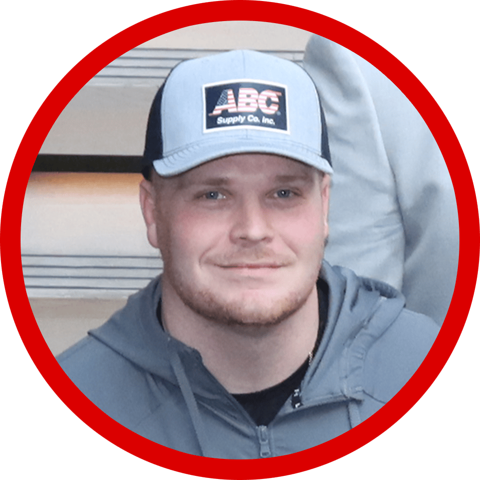 A man with a beard and a cap smiling at the viewer.