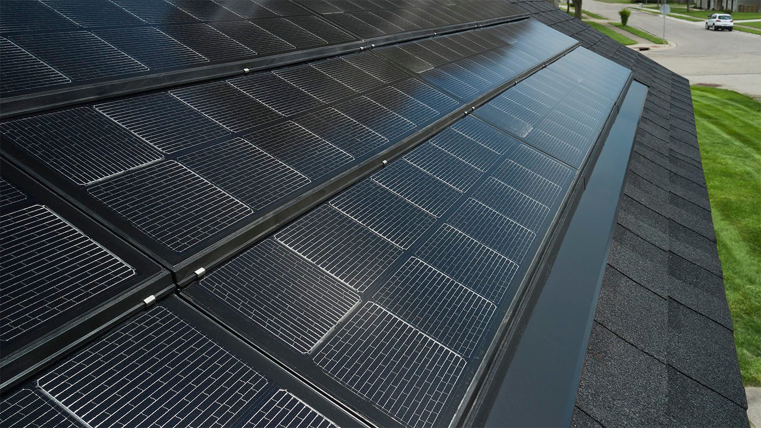 Dark solar panels integrated into a shingled roof.