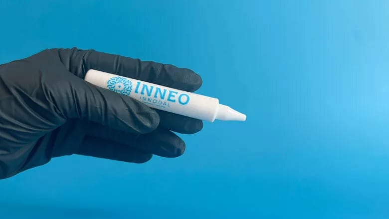 A gloved hand holds a white applicator tube labeled "INNEO INNODAL" against a blue background.