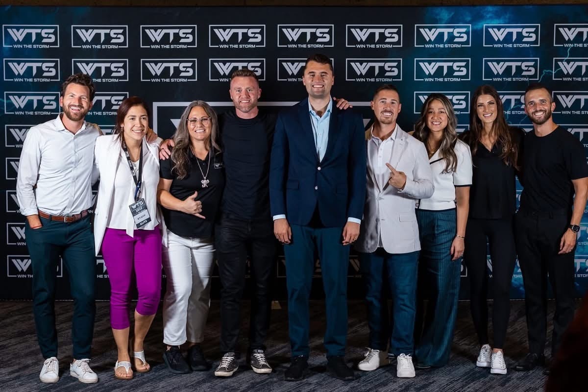Nine smiling people pose at a "Win The Storm" event.