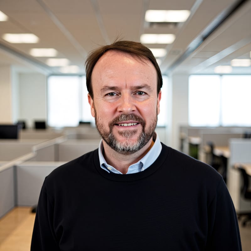 Smiling man with a beard in an office setting.