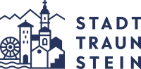 Logo for Stadt Traunstein, featuring stylized buildings, mountains, and a waterwheel alongside the text "STADT TRAUNSTEIN".
