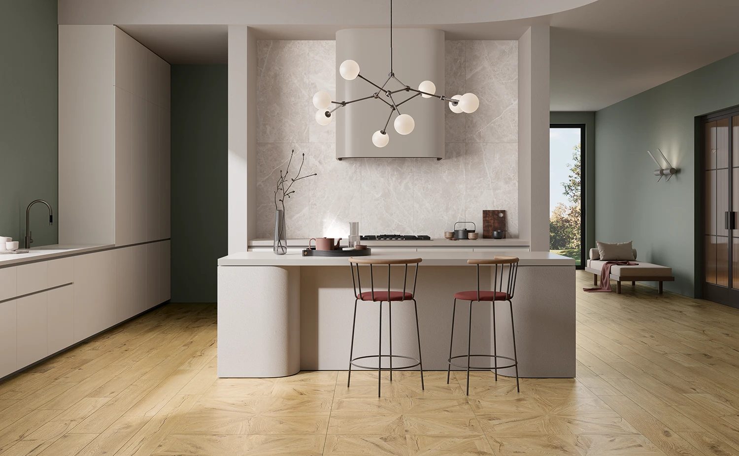 A modern kitchen with a large island, light wood floor, green walls, and a stylish chandelier.