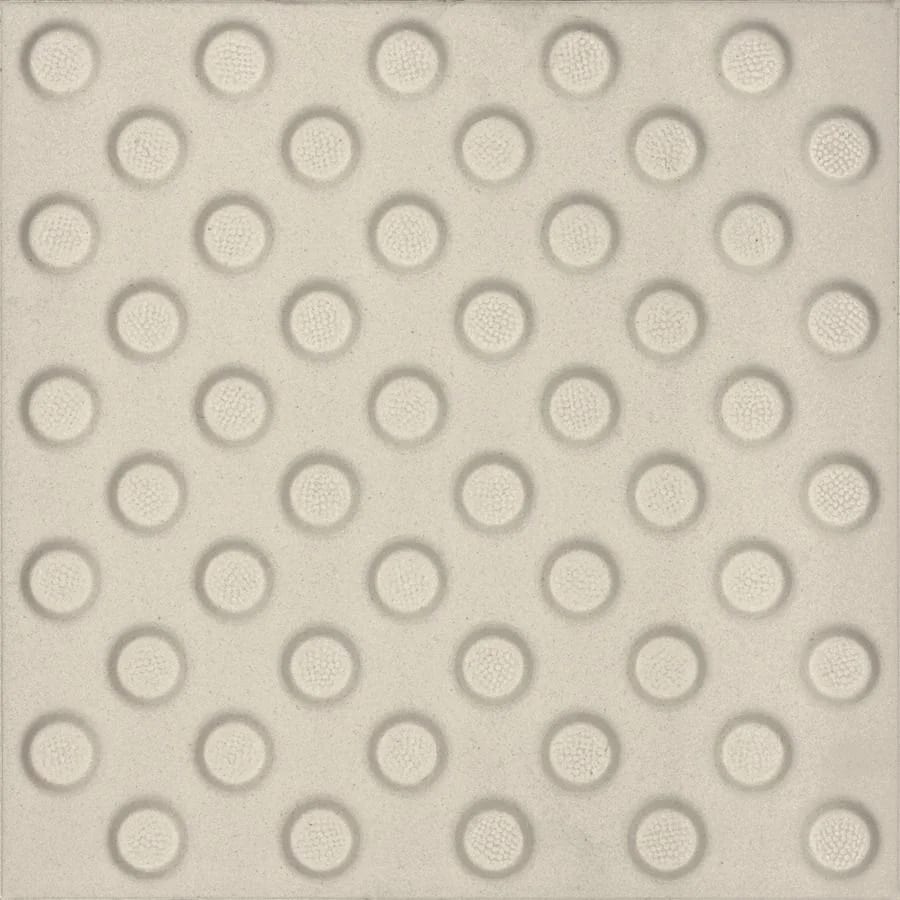 Cream tactile paving tile with raised circular bumps in a grid.