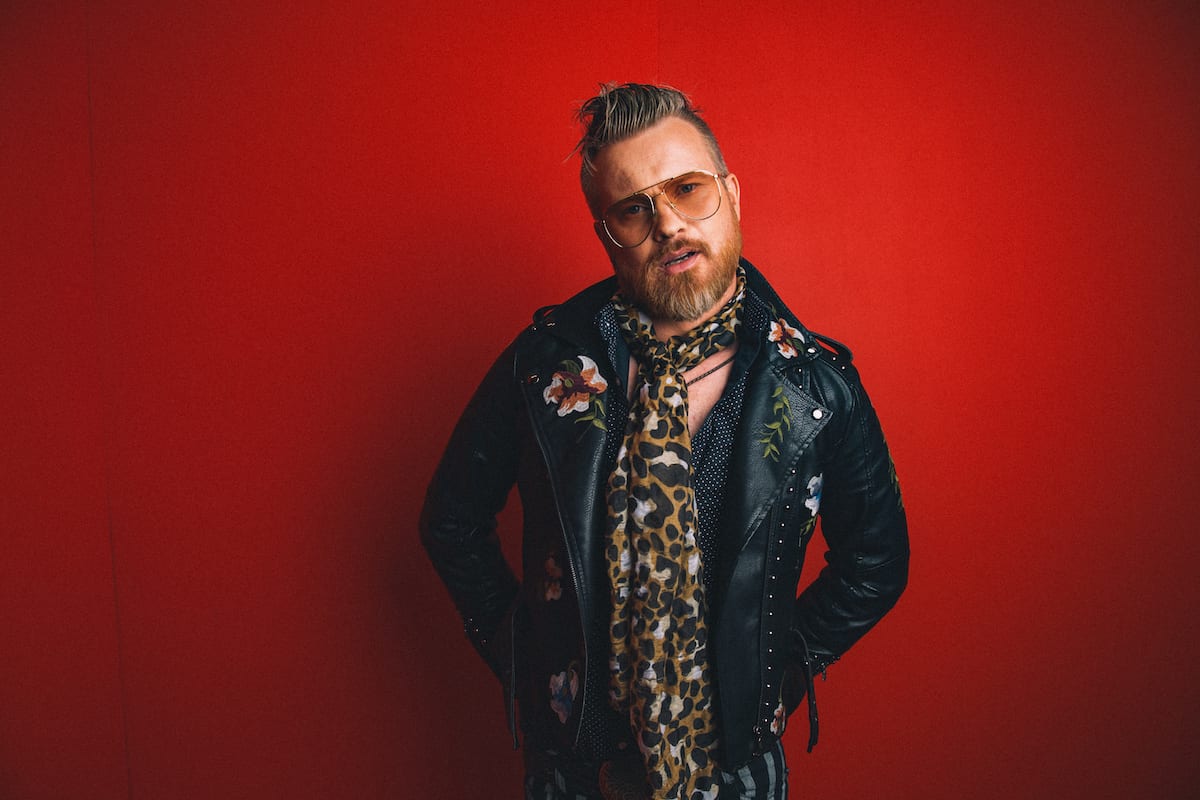 Flash photography, Music artist, Performing arts, Musician, Sleeve, Coat, Beard, Entertainment, Glove