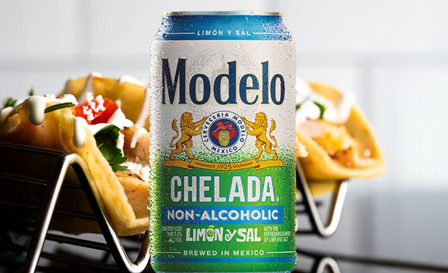 A cold Modelo Chelada Limón y Sal non-alcoholic can with two tacos on stands beside it.