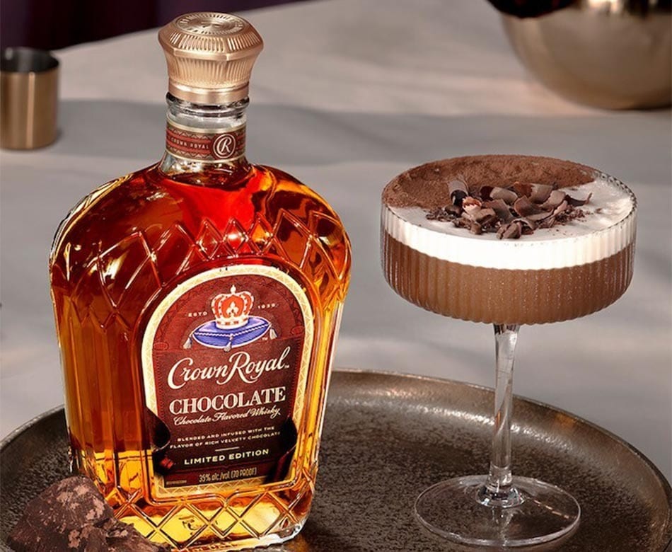 Crown Royal Chocolate whisky bottle next to a chocolate cocktail with whipped cream and chocolate garnish.