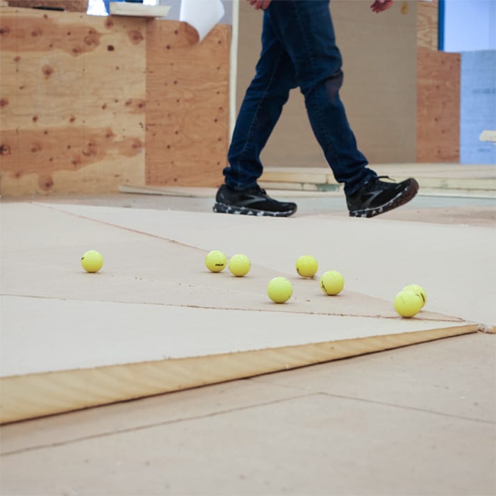 Engineer walking next to yellow balls rolling over a section of tapered insulation.