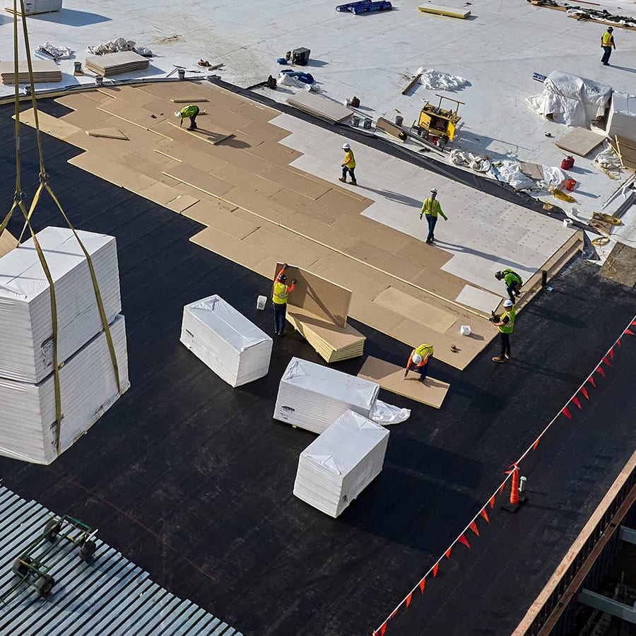 Drone shot of the various stages of roof build in progress on a large commercial roof project.