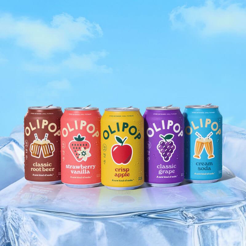 Five colorful Olipop soda cans (root beer, strawberry, apple, grape, cream soda) on ice.