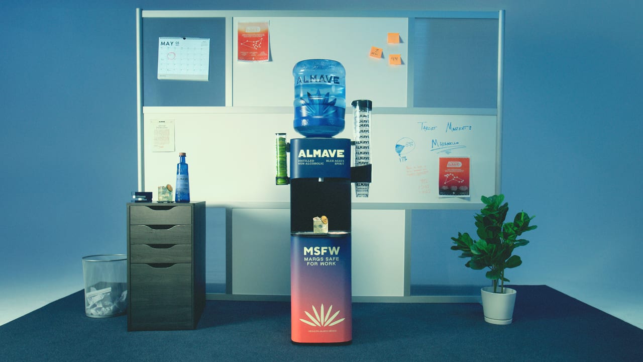 An ALMAVE non-alcoholic spirit dispenser in an office setting, labeled "Margs Safe for Work."