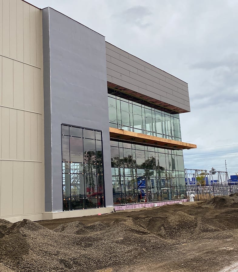 Modern commercial building construction, side view of glass and wood details over walls.