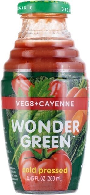 A bottle of Wonder Green Veg8+Cayenne cold-pressed organic juice, featuring images of vegetables like spinach, peppers, and tomatoes on the label.