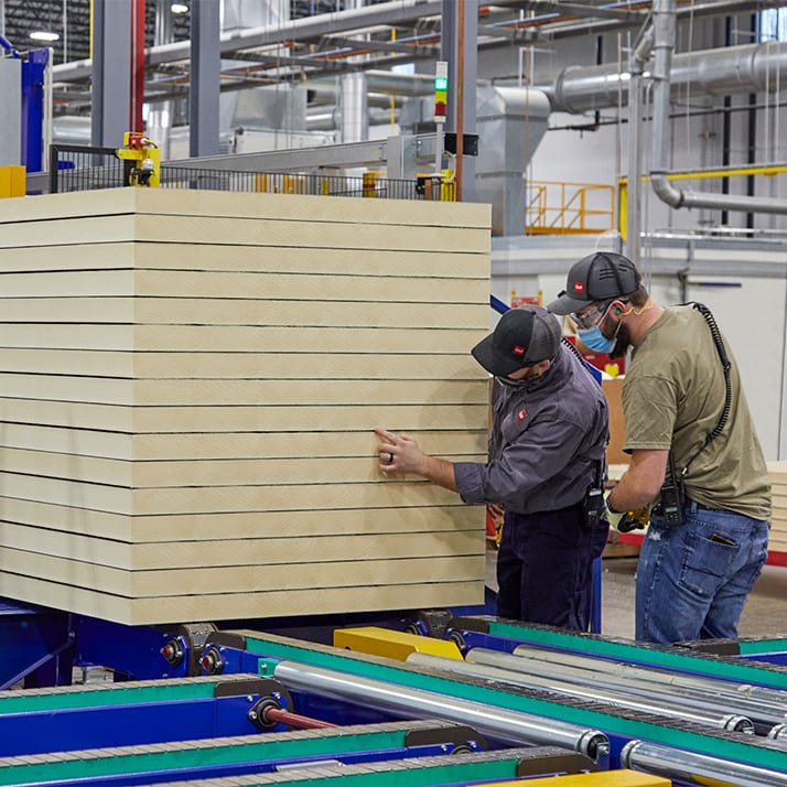 Two men closely inspecting polyiso sheet.