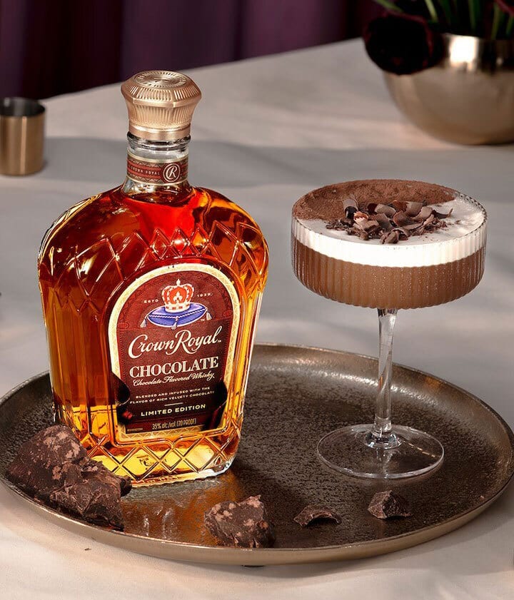 Crown Royal Chocolate whisky bottle and a chocolate cocktail on a tray with chocolate pieces.