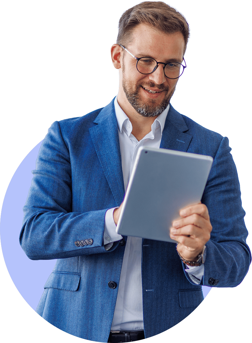 Smiling man in blue suit and glasses holding a tablet.