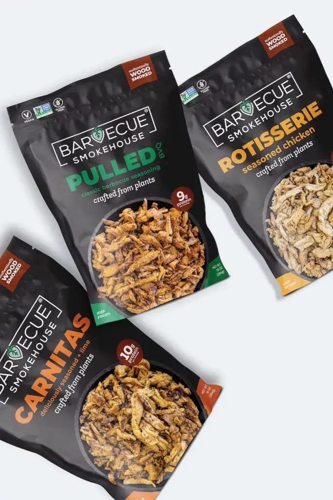 Three Barvecue Smokehouse plant-based meat pouches: Pulled, Rotisserie, and Carnitas flavors.