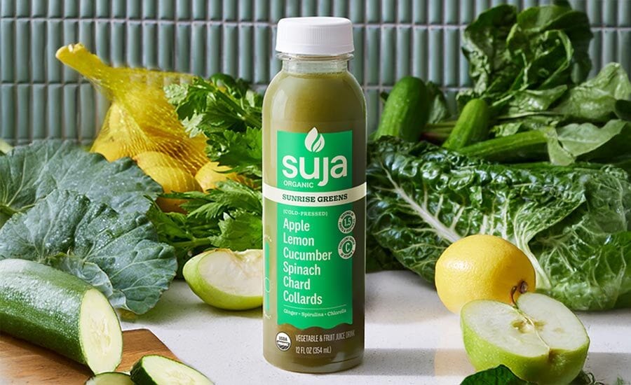 Suja Sunrise Greens juice bottle with fresh apple, lemon, cucumber, and leafy greens.