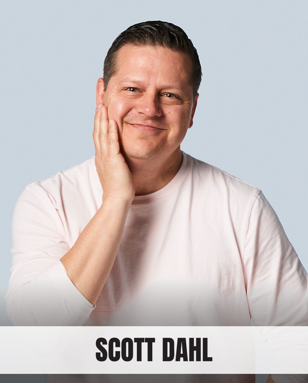 Scott Dahl, a smiling man in a pink shirt with his hand on his cheek.
