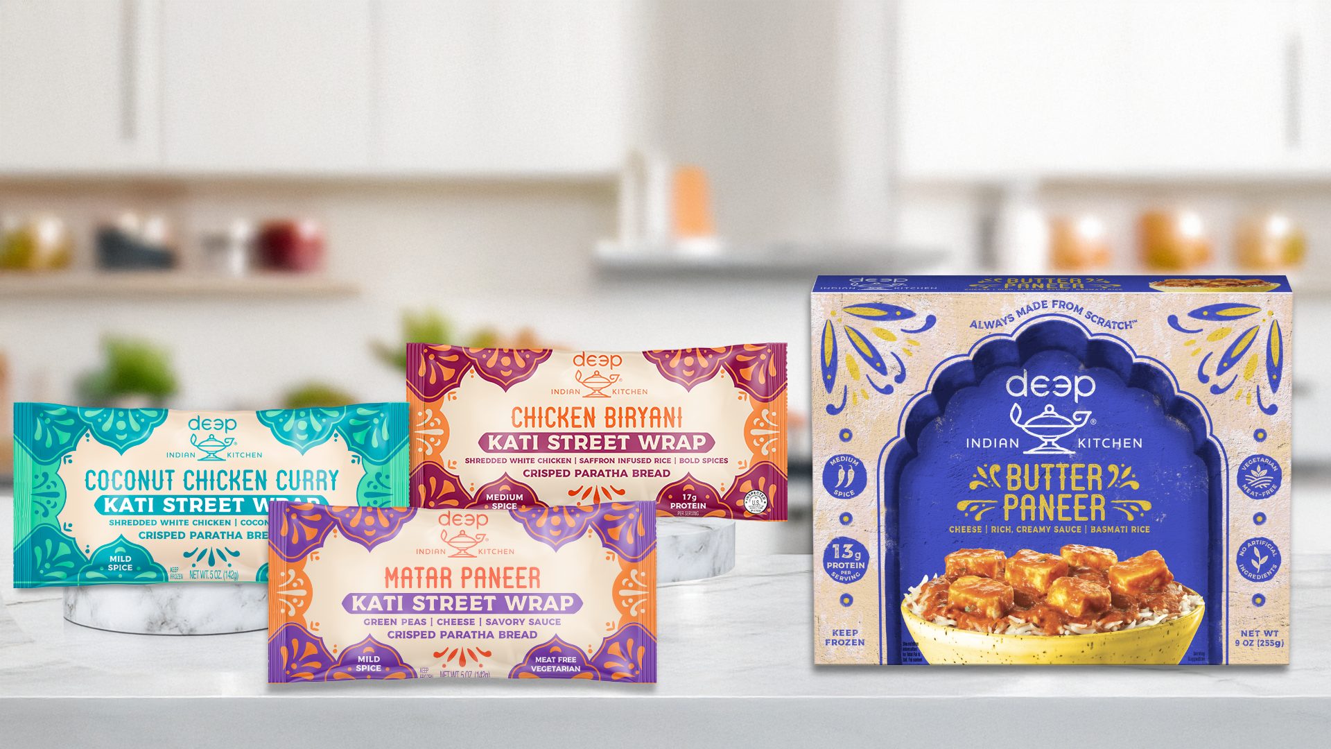 Assortment of Deep Indian Kitchen frozen meals including Kati Street Wraps (Coconut Chicken, Chicken Biryani, Matar Paneer) and Butter Paneer.