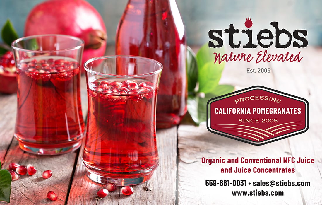 Stiebs pomegranate juice, whole pomegranates, arils, and branding on a wooden surface.