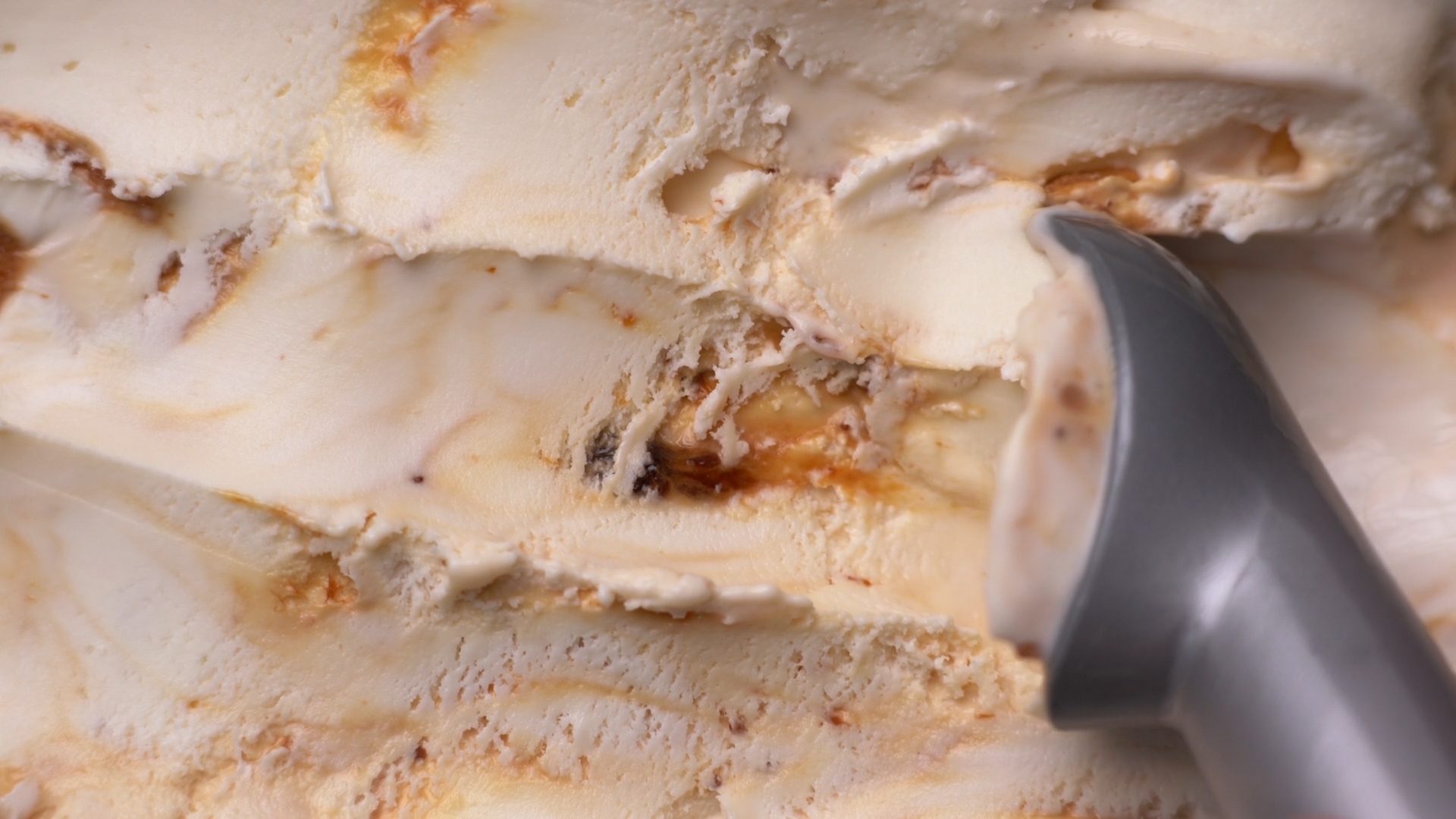 Close-up of caramel swirl ice cream being scooped.