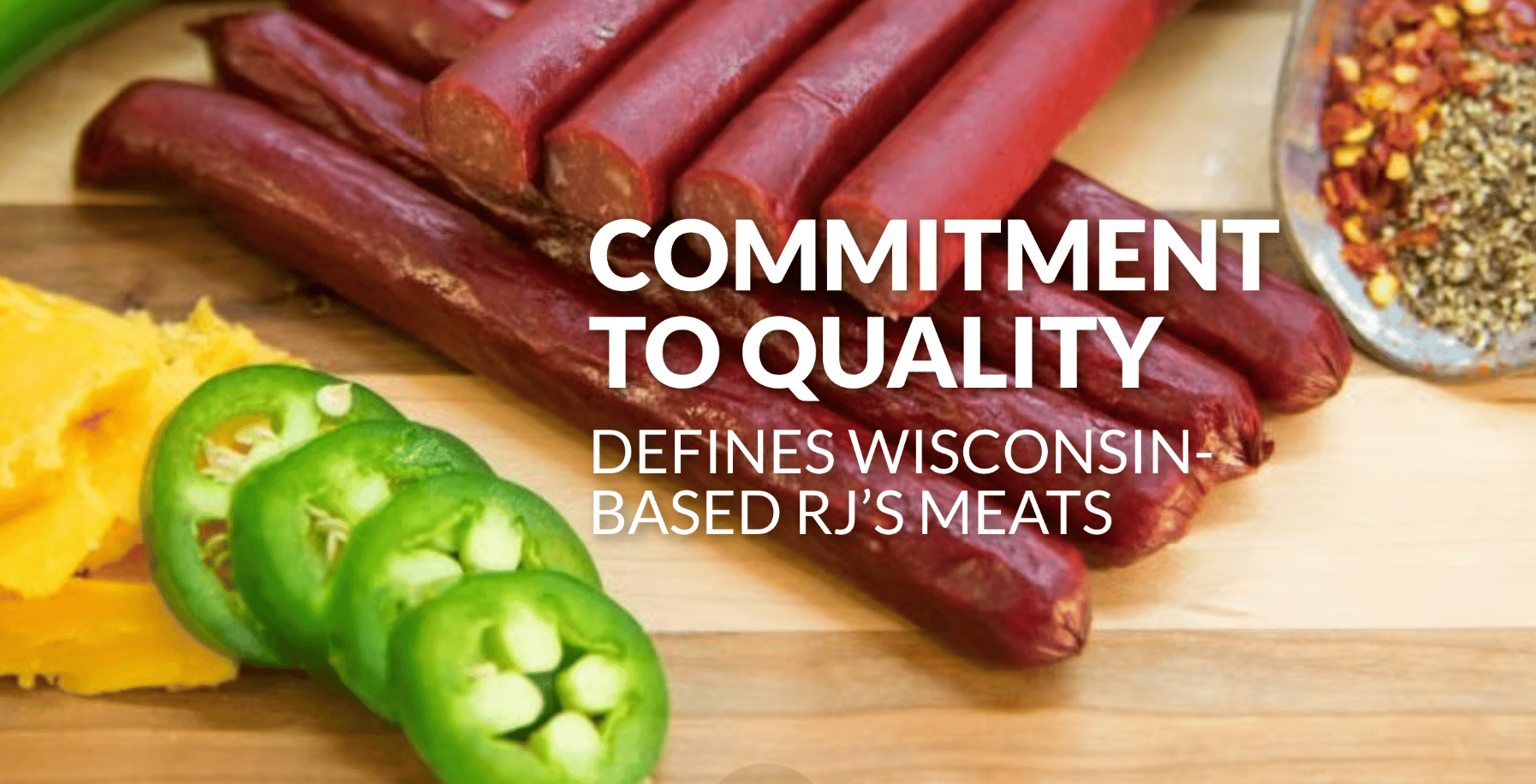 Wisconsin-based RJ's Meats' meat sticks, cheese, jalapeños, and spices on a wooden board.
