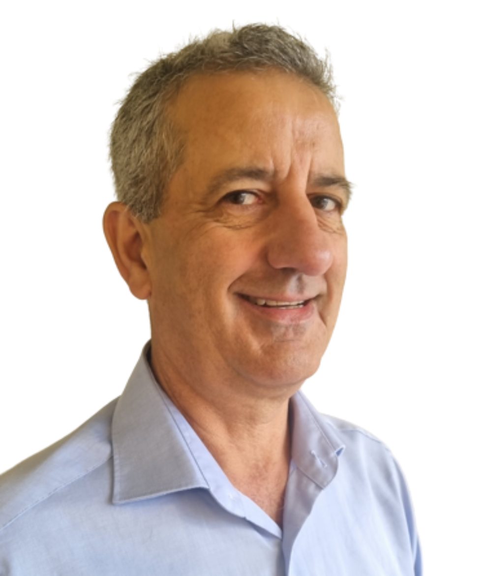 Portrait of a smiling middle-aged man with grey hair and a light blue shirt on a white background.