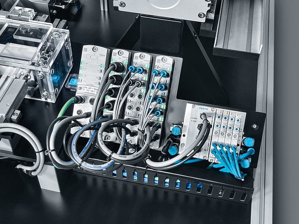 Close-up of Festo CPX-AP-I control modules, pneumatic manifold, and extensive cabling in an industrial setup.