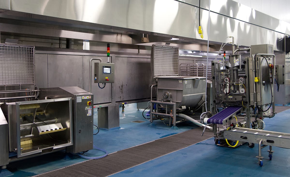 Clean, modern food processing facility with stainless steel equipment and conveyors.