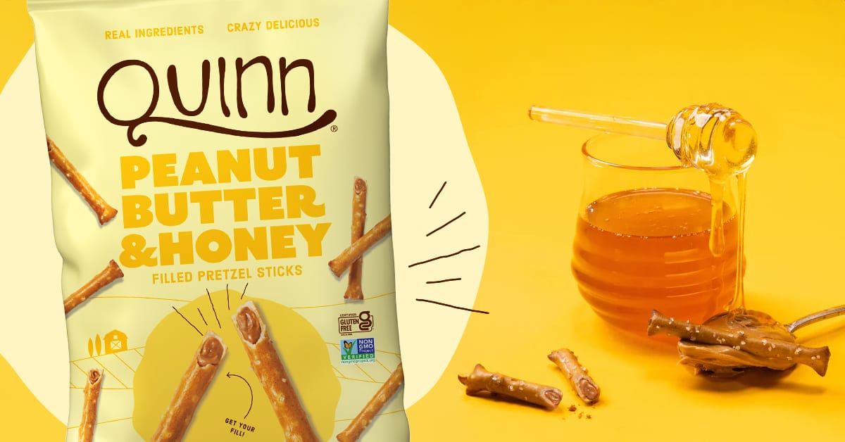 A bag of Quinn Peanut Butter & Honey Filled Pretzel Sticks next to honey and peanut butter.