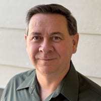 Smiling man with short dark hair.